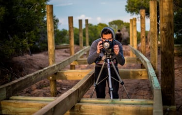 un hombre tomando una fotografía en un antiguo puente de madera