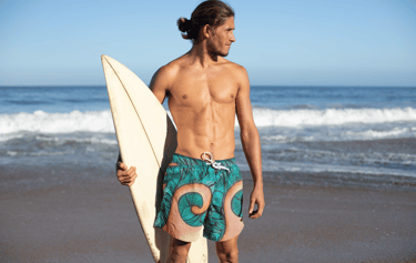 a man in a swimsuit is holding a surfboard