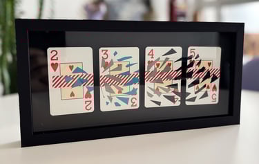 imagem da obra, composta por 4 cartas de baralho com intervenções de washi tape e fita isolante, emolduradas com fundo preto.