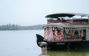 An Indian bride in a pink lehenga arrives by traditional houseboat on the Kerala backwaters.