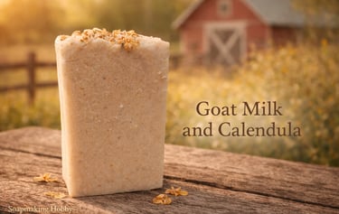 Handmade goat milk and calendula soap bar on a rustic wooden table with a red farm barn background.