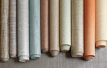 Textured wallpaper rolls in various colors and patterns for modern interior design and home decor.