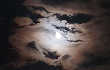a full moon in the sky with clouds shot during night boat tour