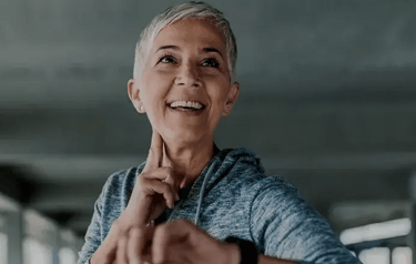 woman smiling while checking her pulse after a workout.