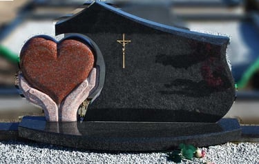 juodos spalvos kareliško akmens paminklas su rudo akmens širdimi