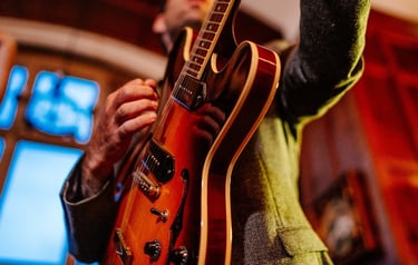 a man holding a guitar and playing a guitar