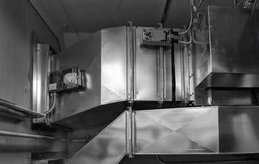 Industrial HVAC metal air ductwork system with motorized fire dampers for commercial ventilation.
