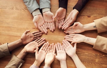 6 people's hands palms up making a circle