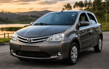 Toyota Etios Sedan cinza estacionado em estrada com lago e montanhas ao fundo.