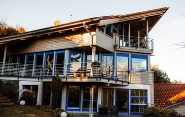 large wooden house with impressive window front and balconys