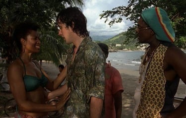 a man and woman standing in front of a beach