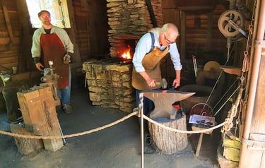 Huntsville, AL - Living history: the blacksmith hammers hot steal into a hook for the barn