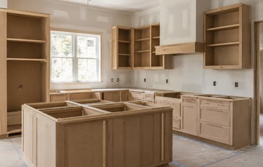 Unfinished custom kitchen cabinets and island being installed during a home renovation project.