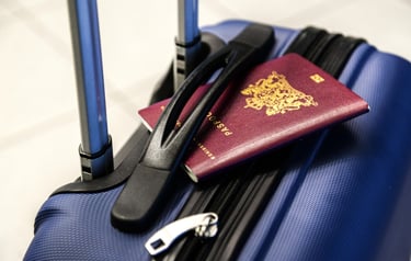 A passport resting on top of a suitcase, suggesting travel or preparation for a trip