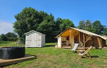 a tented out in a field with a hot tub and a hot tub