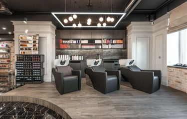 Modern spa & salon interior with professional black leather chairs, and luxury hair products.