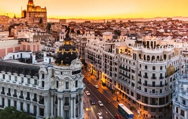 Sunset cityscape over Madrid, Spain featuring the historic Metropolis Building and Gran Via street.