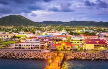 Aerial view of Basseterre, St. Kitts at dusk featuring colorful waterfront buildings and harbor.