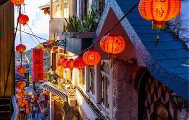 Red paper lanterns glowing along the narrow stone alleys of Jiufen Old Street in Taiwan.