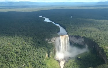 Aerial view of Kaieteur Falls in Guyana surrounded by lush tropical rainforest and the Potaro River.
