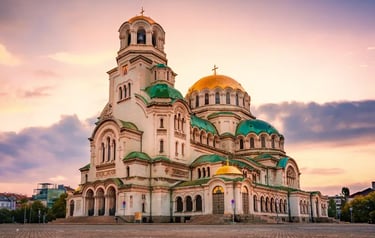 The Alexander Nevsky Cathedral in Sofia, Bulgaria, featuring gold domes at sunset.