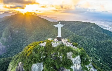 Aerial view of Christ the Redeemer statue atop Corcovado Mountain in Rio de Janeiro at sunset.