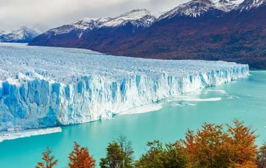 The massive Perito Moreno Glacier in Patagonia, Argentina, meeting turquoise water near snow-capped mountains.