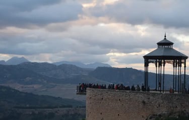 Tourists at the Ronda overlook gazebo enjoying scenic mountain views in Andalusia, Spain.