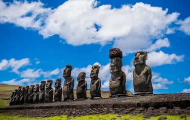 A row of ancient Moai statues standing on Ahu Tongariki under a blue sky on Easter Island.
