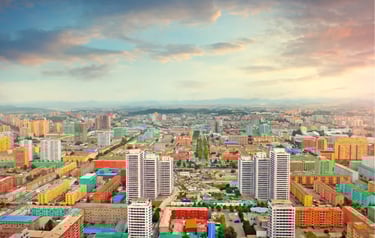 Aerial view of colorful residential apartment buildings in Pyongyang, North Korea at sunset.