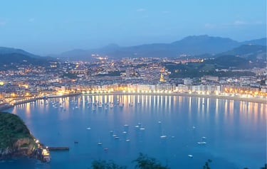 Twilight aerial view of La Concha Bay and San Sebastian city lights in Basque Country, Spain.