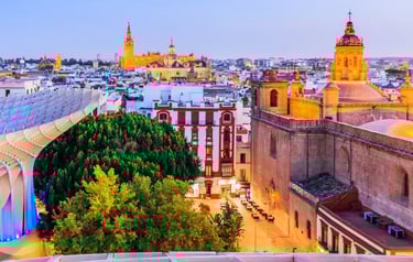 Sunset view of the Seville skyline featuring the Cathedral, Giralda tower, and Metropol Parasol.