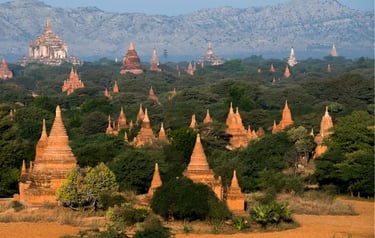 Ancient brick pagodas and Buddhist temples scattered across the lush plains of Bagan, Myanmar.