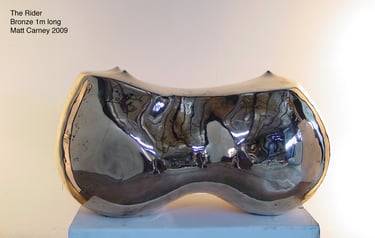 a polished bronze reflective sculpture of curved abstract form