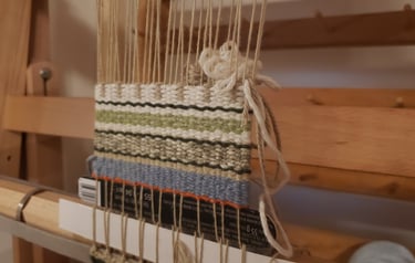 a weaving loom with a partially completed weaving project on it