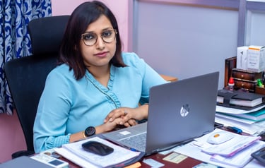 a woman sitting at a desk with a laptop computer