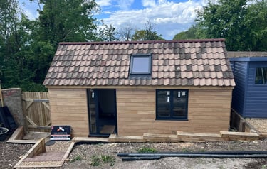 Front view of fully insulated Brighton garage conversion with timber exterior and rooflight window