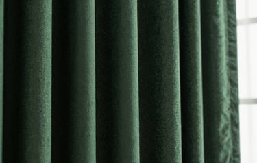 Macro close-up of heavy hunter green curtain fabric texture with deep folds and dramatic side lighting, 35mm