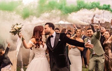 bisou des mariés devant famille et fumigènes