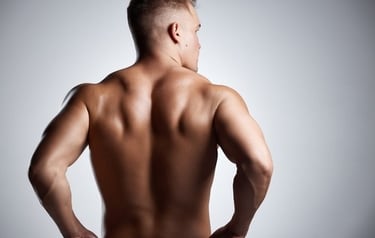 Muscular man displaying defined back muscles and triceps in a fitness bodybuilding pose.