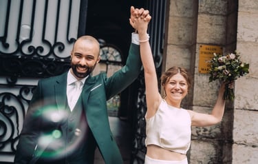 Deux mariés souriants se tenant la main en sortant de la mairie suite à leurs fiançailles