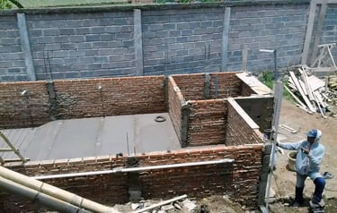 proses pembuatan kolam renang dengan bata merah sebagai penahan beton bagian luar.