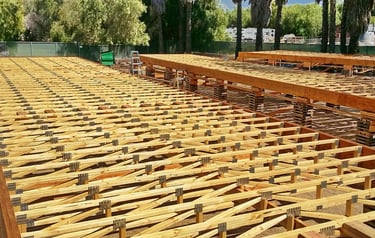 Large modular floor assembly being constructed above ground.