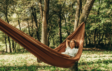 mulher curtinho a tranquilidade do parque natural deitada na rede