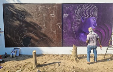 Artist painting a large outdoor mural featuring faces and panthers at centro Mukanranko