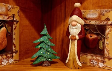 Hand  Santa in robe and hat beside a decorated xmas tree,.  Carved by James Smith