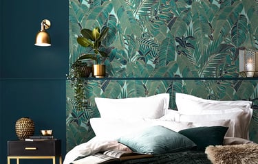 Elegant bedroom featuring tropical teal palm leaf wallpaper and luxury gold decor accents.