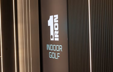 The foyer and video screen of 1IRON indoor golf simulator venue