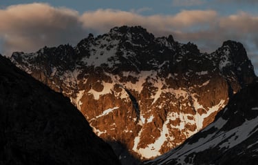 Levé de soleil au travers des nuages sur la Roche d'Alvau (Ecrins)