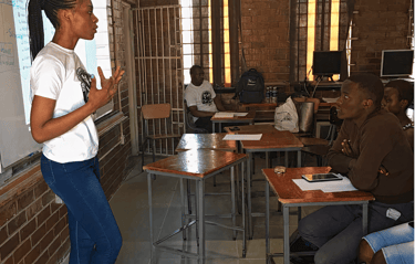 a woman standing in front of a class room